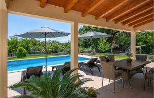 patio ze stołem i krzesłami oraz basenem w obiekcie Amazing Home In Labin With House A Panoramic View w mieście Labin