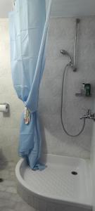 a shower in a bathroom with a blue shower curtain at Dimitra's in Amarynthos