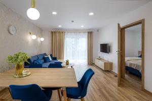a living room with a blue couch and a table at Apartamenty Pod Lipami in Kudowa-Zdrój