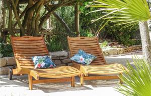 two wooden chairs sitting next to each other with pillows at Nice Home In Plouguerneau With Wifi in Plouguerneau +38 photos