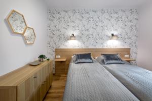 a bedroom with a bed and a mirror on the wall at Apartamenty Pod Lipami in Kudowa-Zdrój