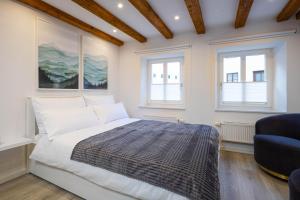 a bedroom with a bed and a blue chair at Stadtmauer-Apartments - Neue helle Studio Wohnung direkt an der historischen Stadtmauer in Nördlingen