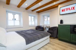 um quarto com uma cama e uma placa de netflix na parede em Stadtmauer-Apartments - Neue helle Studio Wohnung direkt an der historischen Stadtmauer em Nördlingen