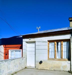 Casa blanca con puerta y ventanas blancas en Odelbor Departamento en Ushuaia