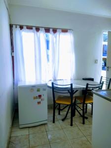 La cuisine est équipée d'une table, de chaises et d'un réfrigérateur. dans l'établissement Odelbor Departamento, à Ushuaia