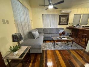 uma sala de estar com um sofá e uma mesa em The Coral Casa em Caye Caulker