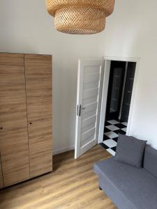 a living room with a couch and a closet at Urokliwy loft w NCŁ kamienica Vabank 34 in Łódź