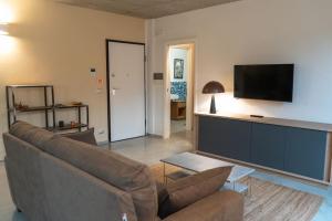 uma sala de estar com um sofá e uma televisão de ecrã plano em Centro Storico Recinto dei Nobili 1 - private parking em Asti