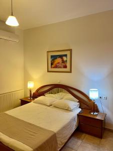 a bedroom with a large bed with two night stands at Elli's apartments in Antimácheia