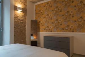 1 dormitorio con cama y pared con chimenea en Centro Storico Recinto dei Nobili 1 - private parking, en Asti