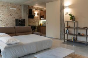 a living room with a large bed and a kitchen at Recinto Nobili 1-private parking su richiesta in Asti