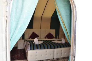 1 dormitorio con 1 cama en una tienda de campaña en merzouga fatima Appart hotel &Camp, en Merzouga