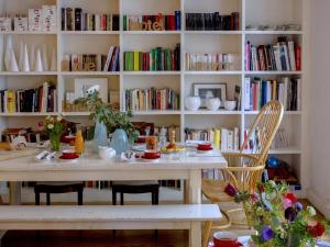 - une table et des chaises dans une pièce avec des livres dans l'établissement Hôtel Arvor Saint Georges, à Paris