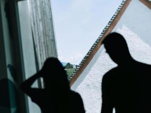 dos sombras de dos mujeres mirando por una ventana en Gourmet - Boutique Hotel Tanzer, en Falzes