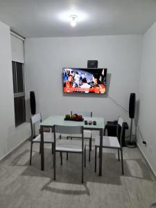 uma sala de jantar com mesa e cadeiras e uma televisão na parede em APARTAMENTO SECTOR CONDINA cerca estadio-ukumari-consota-expofuturo em Pereira