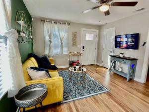 a living room with a yellow couch and a table at Plush Downtown ATL 2BD Home w/ FREE PKNG in Atlanta