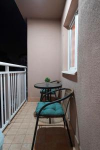 a balcony with a table and a chair and a window at Apartman Nemanja in Bijeljina