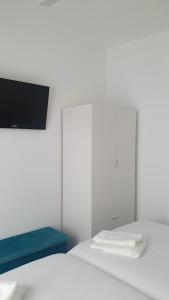 1 dormitorio con 1 cama y TV en la pared en Tres Torres Apartamento Turístico, en Almoharín