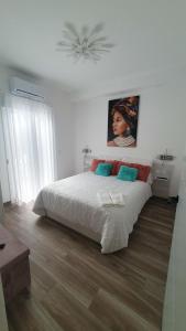 1 dormitorio con 1 cama y una pintura en la pared en Tres Torres Apartamento Turístico, en Almoharín