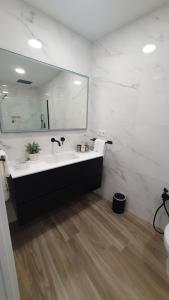 baño con lavabo y espejo grande en Tres Torres Apartamento Turístico, en Almoharín
