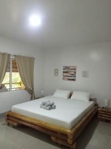 sypialnia z łóżkiem z pluszowym misiem w obiekcie Skott's Comfy Lodge w mieście Wyspa Bantayan