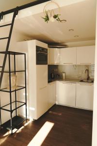 una cocina con armarios blancos y una escalera negra en Royal Opletalova Apartment Prague en Praga