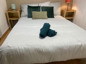 ein weißes Bett mit einem blau ausgestopften Tier drauf in der Unterkunft *NEW* MAISONNETTE*Bail Mobilité*CHIC*NANTES in Nantes