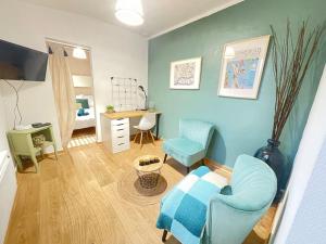 ein Wohnzimmer mit einem blauen Stuhl und einem Schreibtisch in der Unterkunft *NEW* MAISONNETTE*Bail Mobilité*CHIC*NANTES in Nantes