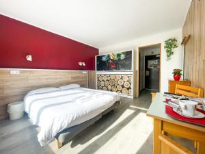 a bedroom with a large bed and a red wall at Atmosphere Hotel in Les Deux Alpes