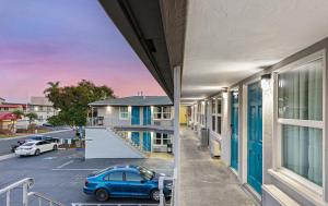 un coche azul estacionado en un estacionamiento junto a un edificio en Hotel Point Loma, en San Diego 4 fotos más