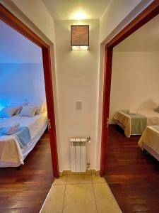 Cette chambre comprend 2 lits et une porte menant à une chambre. dans l'établissement Departamento Güemes II, à San Salvador de Jujuy