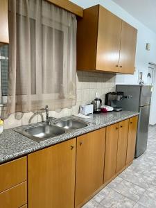 a kitchen with a sink and a refrigerator at Elli's apartments in Antimácheia