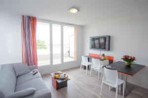 a living room with a couch and a table at Adonis Paris Sud in Chevilly-Larue