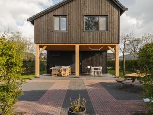 een huis met een veranda en een patio bij Beautiful luxury holiday home with rural character in Ruinerwold