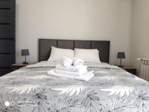 um quarto com uma cama com 2 toalhas e 2 candeeiros em Apartmets Domovik Вместительная трьохкомнатная квартира em Mukacheve