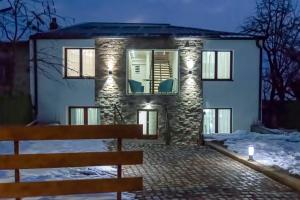 Gora Apartments Premium Lodge - Stara Planina في Balta Berilovac: بيت حجري أمامه جلسة