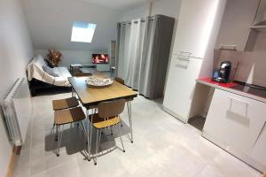 a kitchen with a table and chairs in a room at Lumineux appartement duplex, très bien équipé in Saint-Amand-Montrond