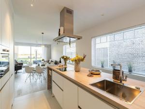 a kitchen with a sink and a large window at Spacious holiday home in Aardenburg with terrace in Aardenburg