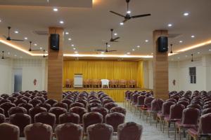 ein leerer Saal mit Sitzreihen und einer Bühne in der Unterkunft HYDEPARK REGENCY in Palakkad