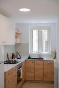 a kitchen with wooden cabinets and a sink and a window at Tiny house in the historic centre of Soverato in Soverato Superiore