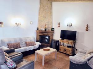 sala de estar con sofás, TV y chimenea en cortijo Maria Gomez, en Málaga