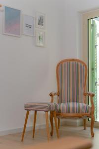 a wooden chair with a striped seat in a room at Tiny house in the historic centre of Soverato in Soverato Superiore