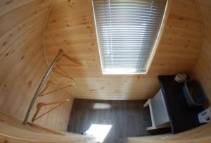 a wooden attic room with a staircase and a tv at Poplars Farm Site Glamping Pods in Hulland