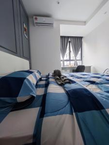 a bedroom with a bed with a blue and white blanket at Swiss Home Horizon Suite 1 in Sepang