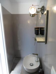 a bathroom with a toilet and a mirror and a light at CASA SYRA in Ermoupoli