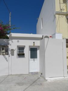 a white building with a door and a window at CASA SYRA in Ermoupoli