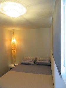 a bedroom with a bed and a chandelier at CASA SYRA in Ermoupoli