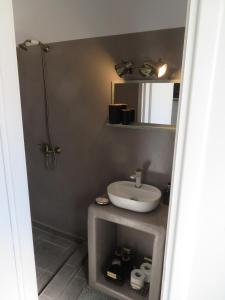 a bathroom with a sink and a mirror at CASA SYRA in Ermoupoli