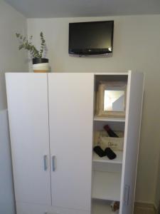 a white cabinet with a tv on top of it at CASA SYRA in Ermoupoli