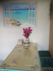 Rhodes Heaven Apartment في Malona Village: طاولة زجاجية عليها إناء من الزهور